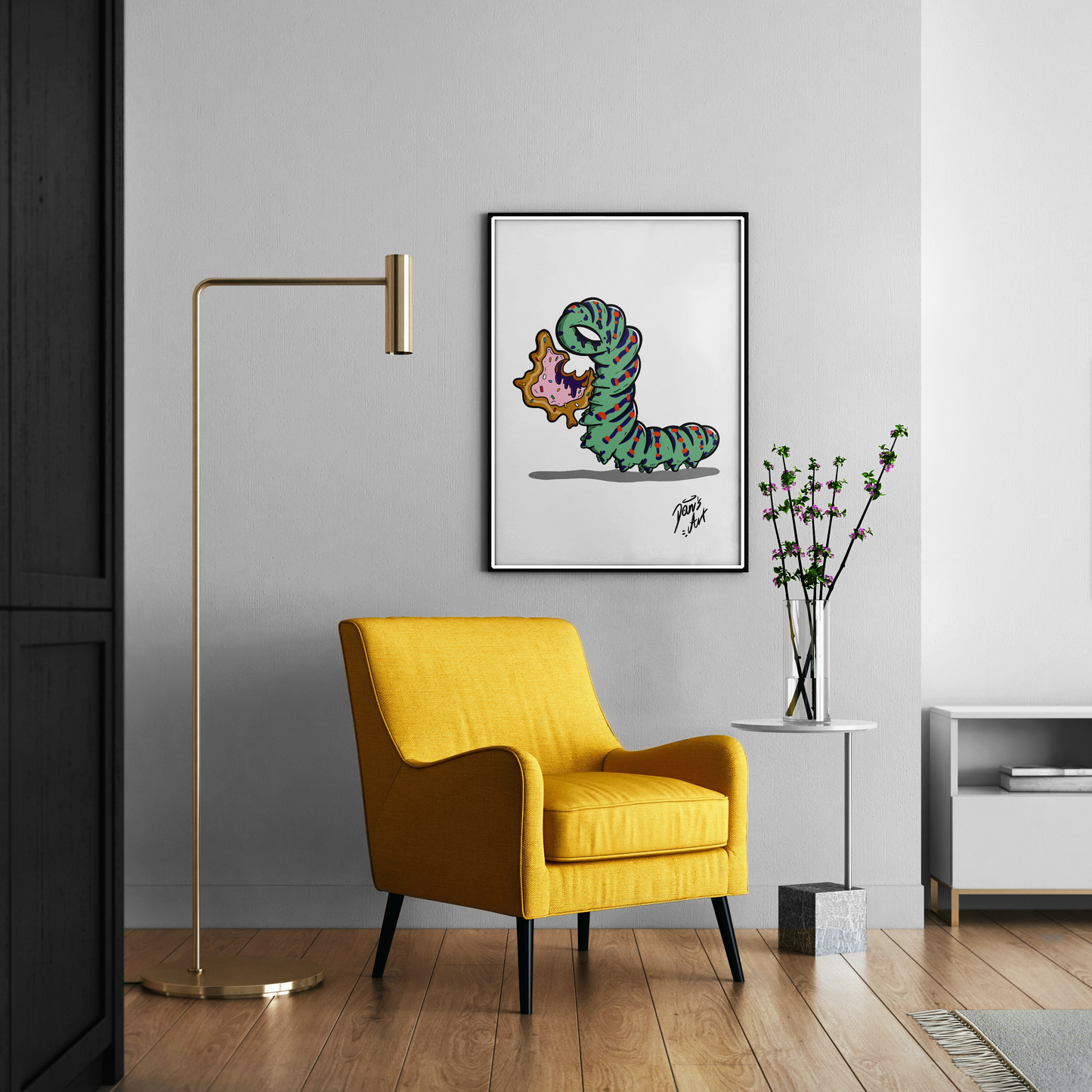 Illustration of a donut-shaped caterpillar eating a donut-style leaf. Displayed on a 50x70cm poster on the wall of a living room.